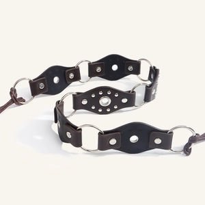 Detail of vintage leather belt with silver metal rings and studs in a trendy retro design
