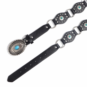 Detalle de cinturón retro western con piedras turquesas y tachuelas de flores de plata