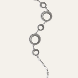 Detail van vintage zilveren ringen met radiale texturen op een metalen lichaamsketting