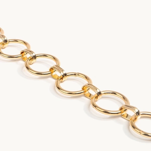 Detail van een gepolijste gouden tailleketting met glanzende geometrische ringvormige links