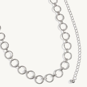 Detailweergave van de zilveren geometrische metalen tailleketting met verlenging en hanger