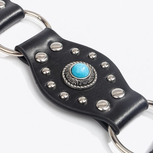 Détail de ceinture bohème en cuir noir avec pierre turquoise et rivets argentés