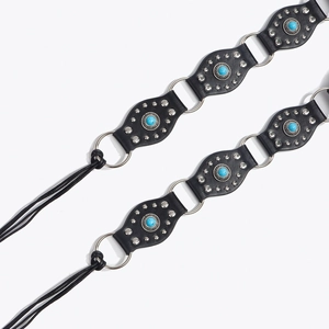 Détail macro de la ceinture bohème avec pierres turquoises, rivets et cuir noir