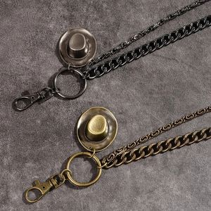 Detail of punk style double-layered metal trouser chains with western cowboy hat charms