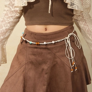 Detail der böhmischen handgewebten Taillenkette mit Perlen und Quasten an braunem Kleid