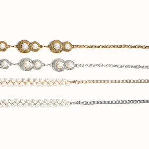 Detail view of pearl waist chains in vintage gold and silver metal textures