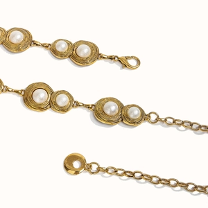Detail of vintage gold metal chain with elegant white pearls and lobster clasp closure