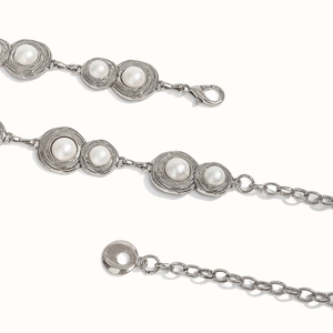 Close-up of vintage silver metal chain belt with white pearls and spiral textures