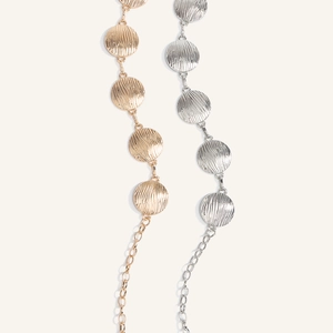 Dettaglio di cinture a catena in oro e argento con placche in metallo dalla texture spazzolata