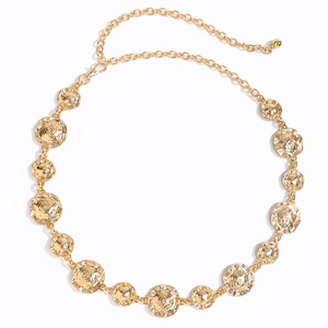 Detailed close-up of golden metal waist chain with embossed spiral textures and lobster clasp