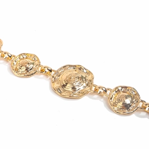 Detailed macro view of golden metal waist chain with rose textured round discs