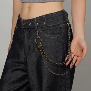 Close-up of triple-layered vintage bronze metal pant chains with a small hat pendant