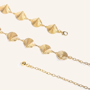 Detail of western retro gold metal waist chain with textured discs and lobster clasp