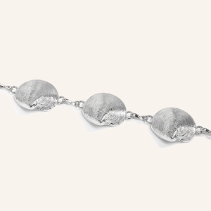 Macro view of silver scallop shell metal links with textured ripple details for women's belt