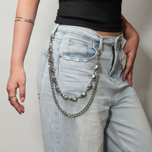 Detail of a punk style double-layered silver skull trousers chain on blue denim jeans
