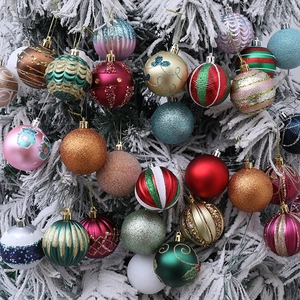 Assorted colorful painted Christmas ball ornaments hanging on a snowy Christmas tree