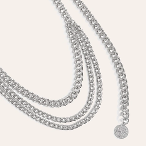 Detail einer mehrlagigen silbernen Metall-Taillenkette mit einem Vintage-Münzanhänger