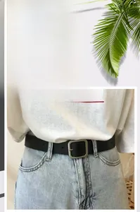 Detail of casual black leather belt with silver square metal buckle on denim jeans