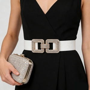 Detail of white elastic belt with sparkling rhinestone double buckle on a black dress