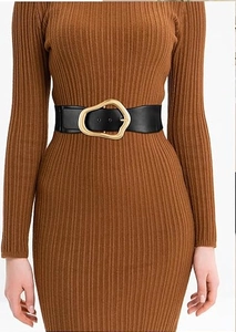 Close-up of a wide black elastic belt with an irregular gold metal buckle on a dress
