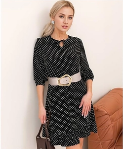 Detail of a dress with irregular gold buckle belt and polka dot pattern fabric