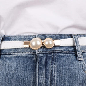 Detail of elegant white leather belt with double pearl buckle and champagne gold hardware