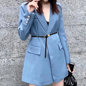 Close-up of a slim black leather belt with golden horseshoe buckle on a blue blazer dress