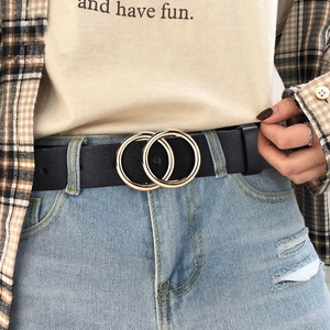 Slim black leather belt for women with double golden O-ring buckle on blue denim jeans