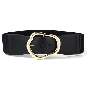 Detail showing the polished golden irregular metal buckle on a black elastic waist belt