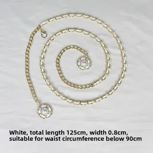 Détail de la ceinture chaîne dorée entrelacée de cuir blanc et pendentifs perles