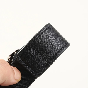 Detailed macro view of black lychee grain leather stitching and elastic belt fabric