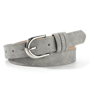 Detailed macro view of grey suede belt with silver metal studs and U-shaped buckle