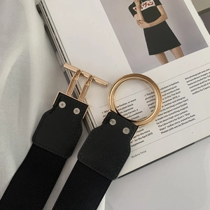 Detail of black elastic waist belt with a polished gold metal OT toggle clasp on a magazine