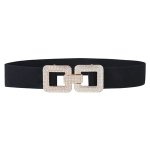 Détail de la boucle dorée carrée à strass sur une large ceinture élastique noire pour femme