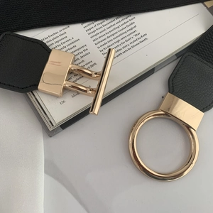 Close-up of black elastic waist belt featuring a polished gold OT metal buckle and PU leather