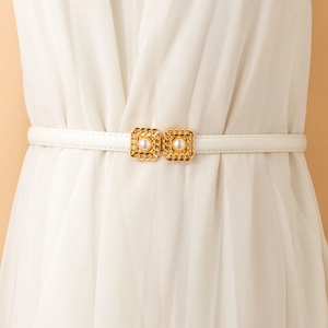 Detail of elegant white leather belt with gold chain buckle and large faux pearls