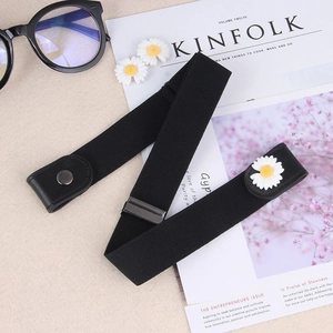 Close-up of black elastic buckle-free belt with daisy floral detail on jeans