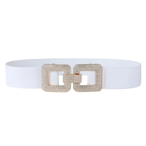 Détail d'une ceinture élastique blanche avec boucle carrée dorée sertie de strass