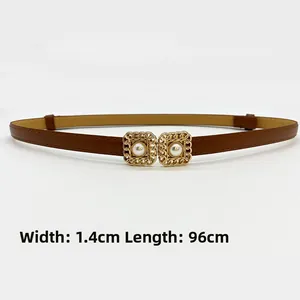 Detail of vintage brown slim belt with golden hollow square buckle and pearl accent