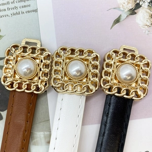 Detailed view of women's vintage belts with gold chain buckles and inlaid pearls