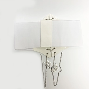 Vue détaillée d'une large ceinture corset blanche élastique avec chaînes et papillons