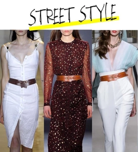Close-up of stylish leather waist belts with gold buckles styled on runway dresses