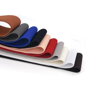 Detailed view of ten colorful braided elastic belts in a stacked layout on marble surface