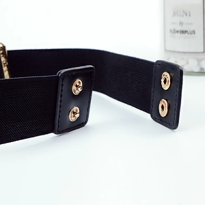 Détail des doubles boutons-pression dorés et coutures en cuir sur la ceinture élastique noire
