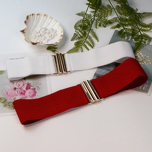 Detail of red and white elastic waist belts with gold metal interlock buckle for dresses