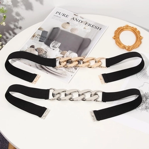 Detail of black elastic waist belts with chunky gold and silver metal chain link buckles