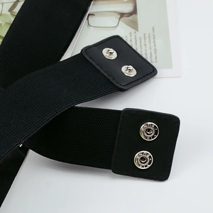 Détail de la ceinture élastique noire avec bouton-pression en métal argenté gravé