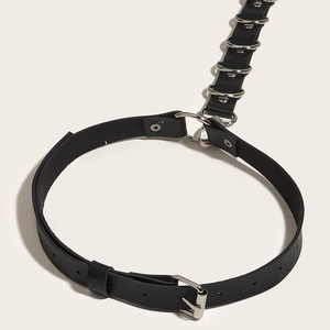 Detail view of black punk leather body harness with adjustable straps and silver D-rings