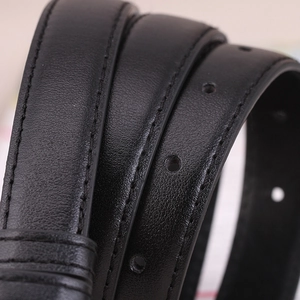 Close-up of a minimalist black leather belt for women featuring fine stitching and buckle holes