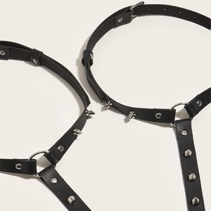 Detail of punk black PU leather garter belt with silver studs and metal ring connectors